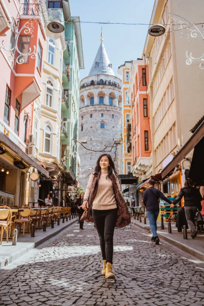 woman-walking-through-alley-full-with-cafe-historical-building-istanbul-turkey